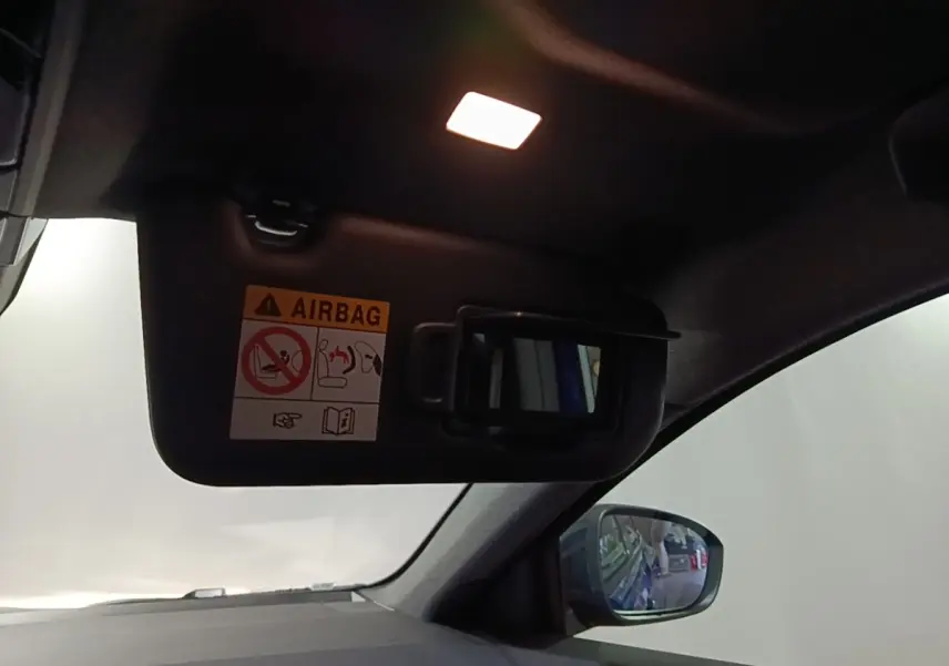 Détail intérieur du pare-soleil côté conducteur avec miroir et avertissement airbag dans un Renault Austral bleu.
