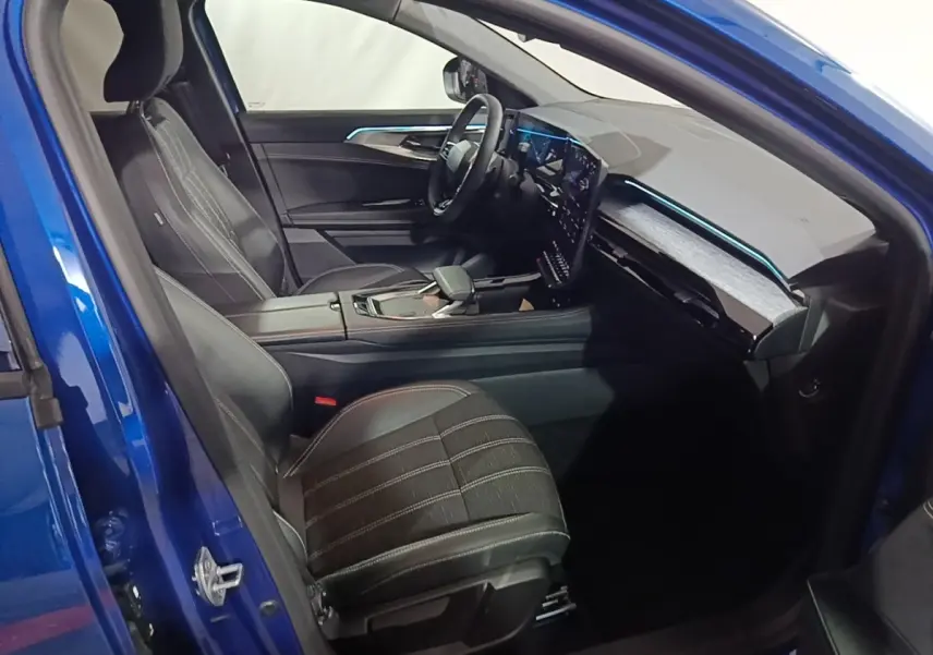 Intérieur du Renault Austral bleu 2024, vue côté conducteur, sièges cuir noirs et tableau de bord digital moderne.
