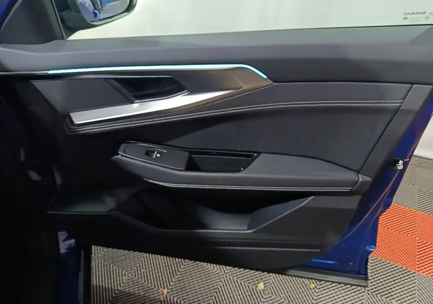 Vue intérieure de la porte avant gauche bleu Renault Austral 2024 avec éclairage d'ambiance et finitions tissu et métal.