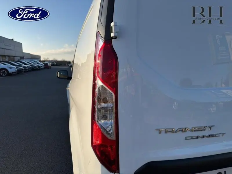 Vue arrière côté gauche du Ford Transit Connect blanc glacier, mettant en valeur le feu arrière vertical et le logo du modèle.