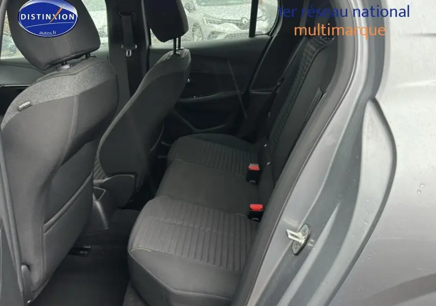 Vue côté droit arrière sur l'intérieur tissu noir/gris de la Peugeot 208 1.2 PureTech 100 Active gris Artense 2024.