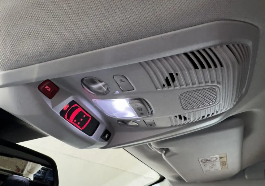 Vue intérieure en gros plan du plafonnier gris avec boutons SOS et éclairage, dans un Peugeot 3008 orange 2020.
