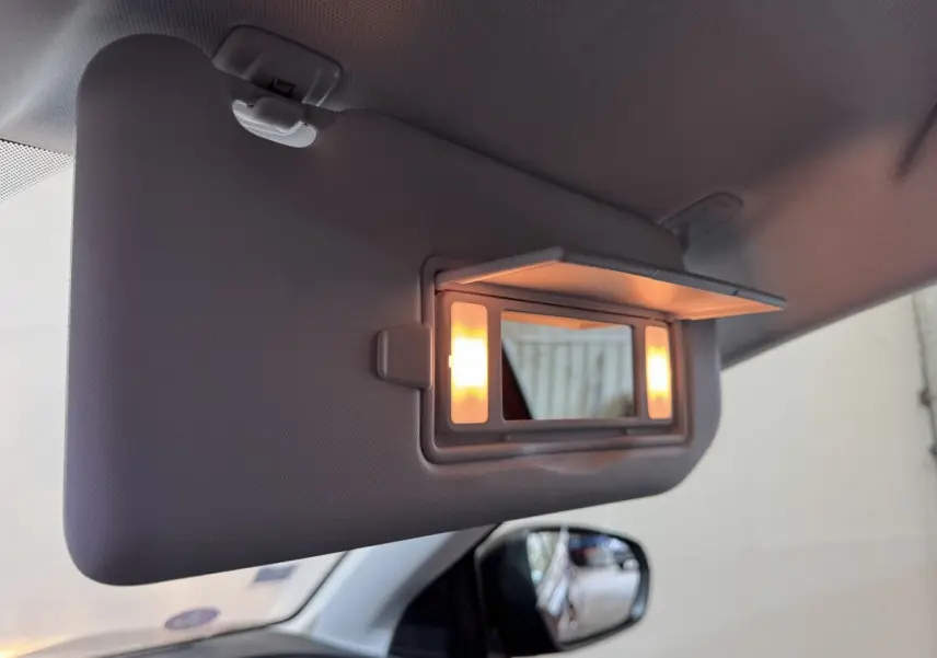 Détail de la visière côté conducteur du Peugeot 3008 orange 2020 avec miroir éclairé et rétroviseur latéral visible.