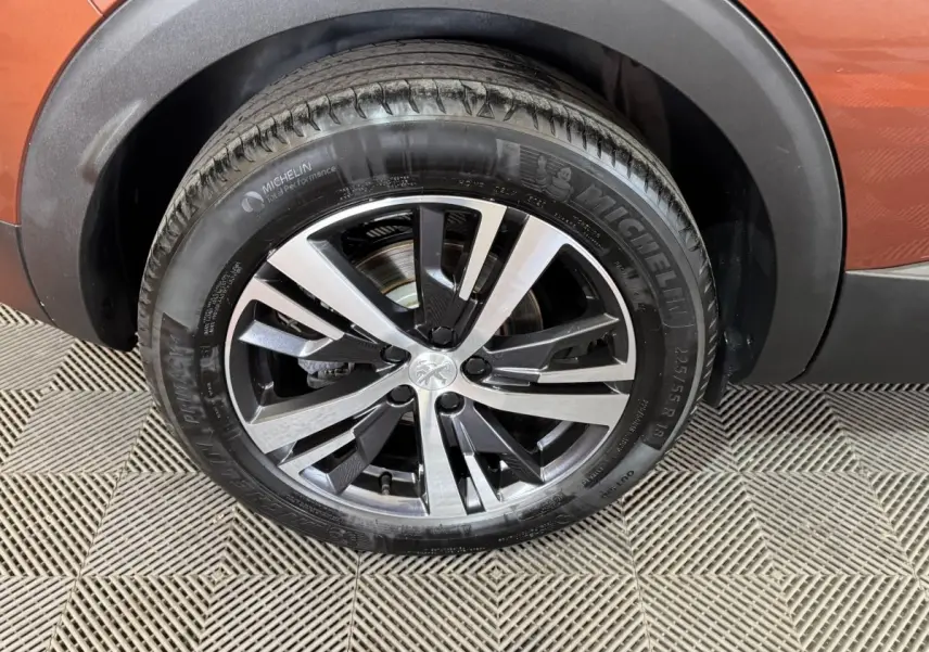 Gros plan sur la roue avant droite du Peugeot 3008 orange 2020 avec jante alliage bicolore et pneu Michelin.