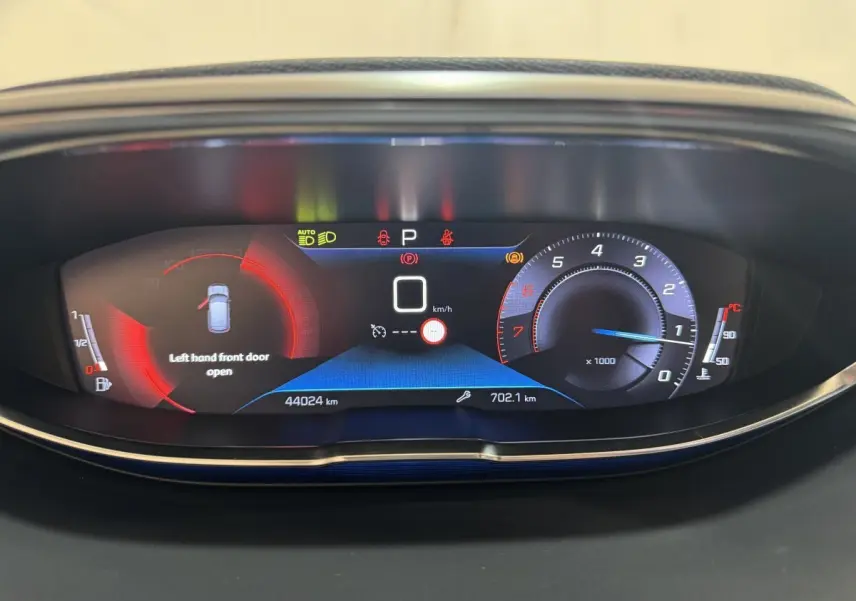 Tableau de bord numérique du Peugeot 3008 PureTech 130, affichant porte avant gauche ouverte et compte-tours bleu.