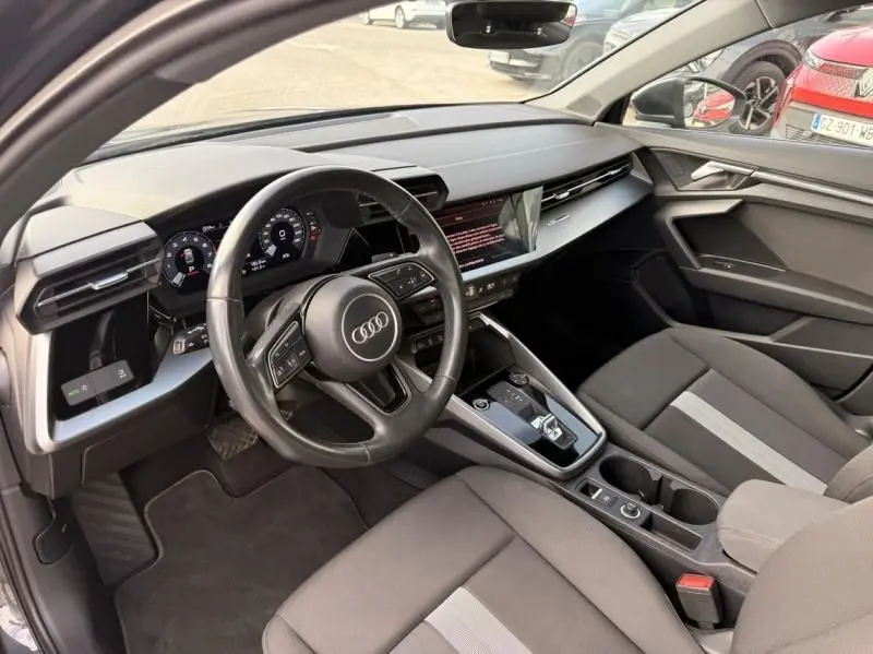 Vue intérieure côté conducteur de l'Audi A3 Berline 35 TFSI 2022, avec tableau de bord numérique et sellerie tissu gris.