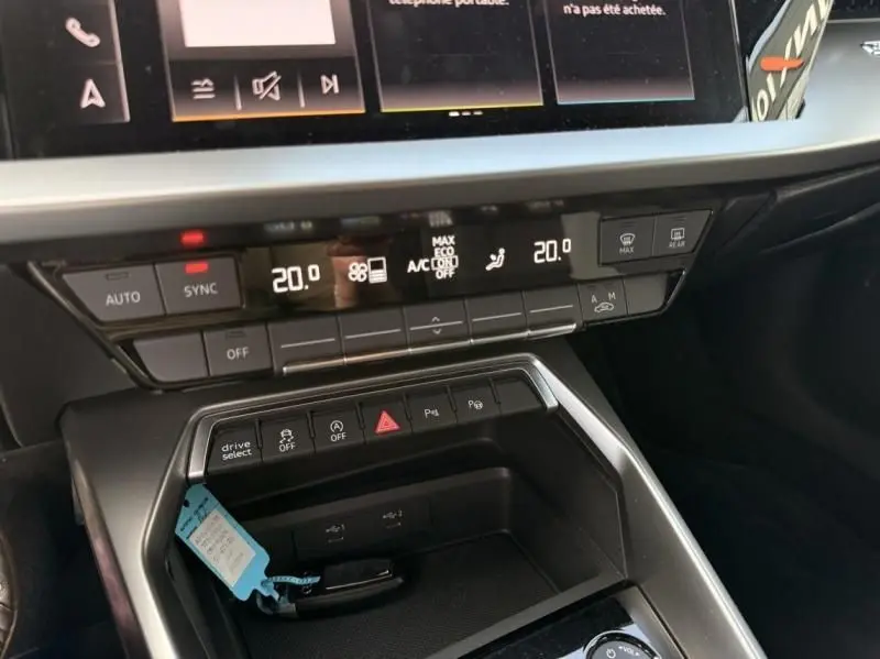 Vue rapprochée du tableau de bord de l’Audi A3 Berline 35 TFSI 2022, montrant les commandes de climatisation et les boutons de fonction.