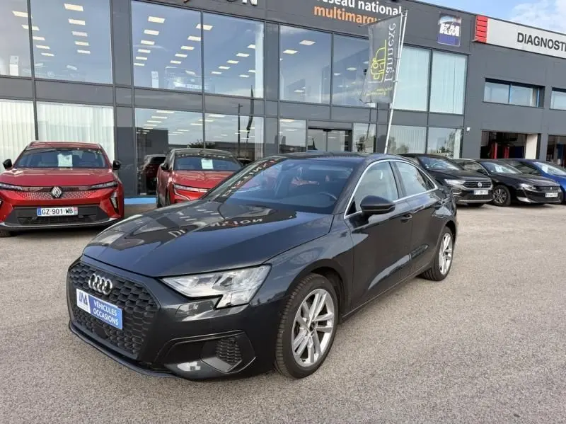 Audi A3 Berline gris foncé métal vue 3/4 avant droit, calandre hexagonale et jantes alliage visibles.