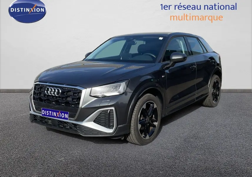 Audi Q2 gris Manhattan métal en 3/4 avant droit, avec calandre noire et jantes noires distinctives.