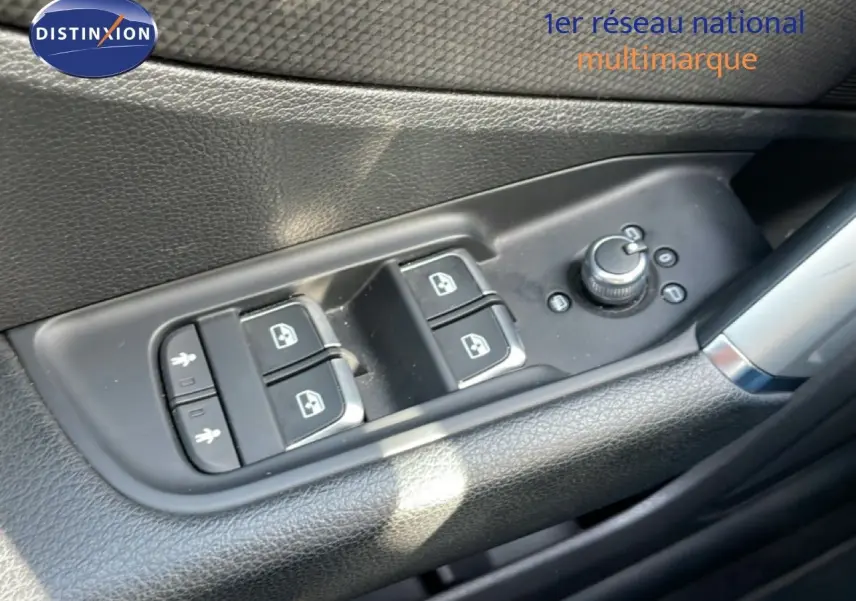 Gros plan sur les commandes des vitres et rétroviseurs côté conducteur d’un Audi Q2 gris Manhattan 2025.