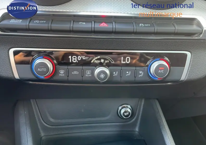 Vue rapprochée de la console centrale de l'Audi Q2 30 TDI S-Line 2025 avec commandes de climatisation digitales.