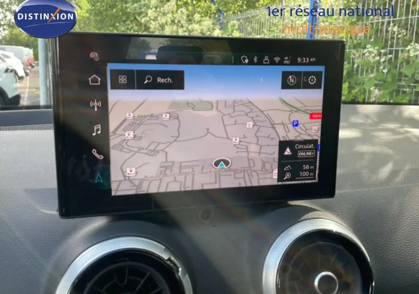Écran tactile central affichant la navigation dans l'Audi Q2 30 TDI S-Line 2025, intérieur noir avec aérateurs ronds argentés.