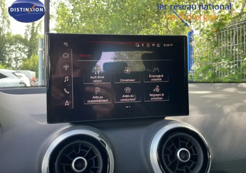 Écran tactile central de l’Audi Q2 30 TDI S-Line 2025, vue intérieure sur la console avec aérateurs ronds.