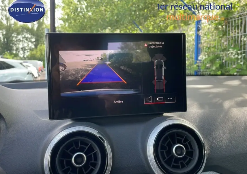 Vue intérieure du tableau de bord de l'Audi Q2 30 TDI S-Line 2025, écran affichant la caméra de recul avec guidage.