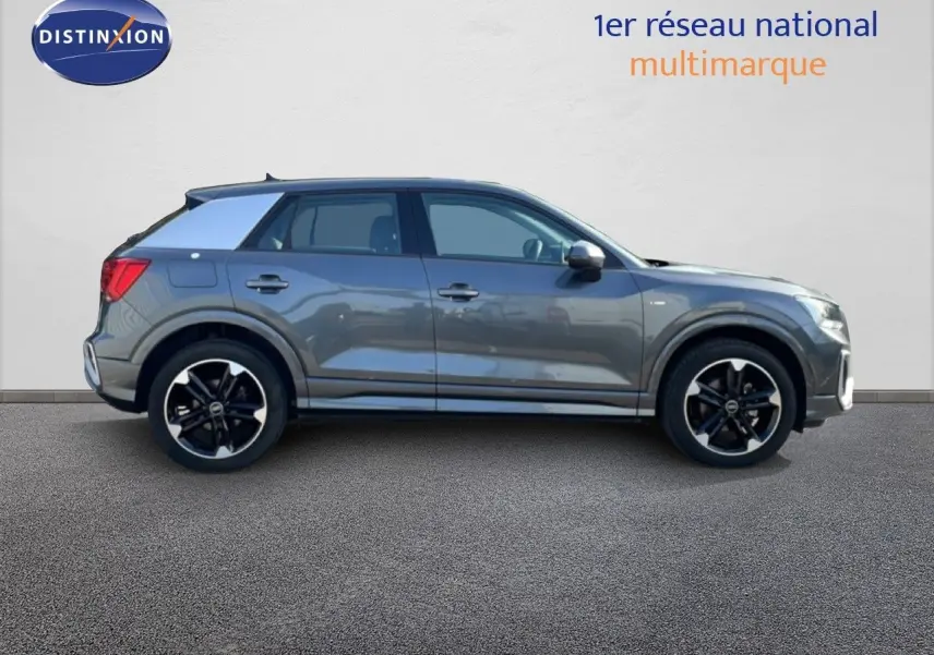 Audi Q2 30 TDI S-Line gris Manhattan vu de profil côté gauche, avec jantes noires et toit contrasté blanc.