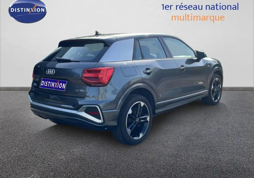 Audi Q2 30 TDI S-Line gris Manhattan, vue 3/4 arrière droit, avec jantes noires et feux LED distinctifs.