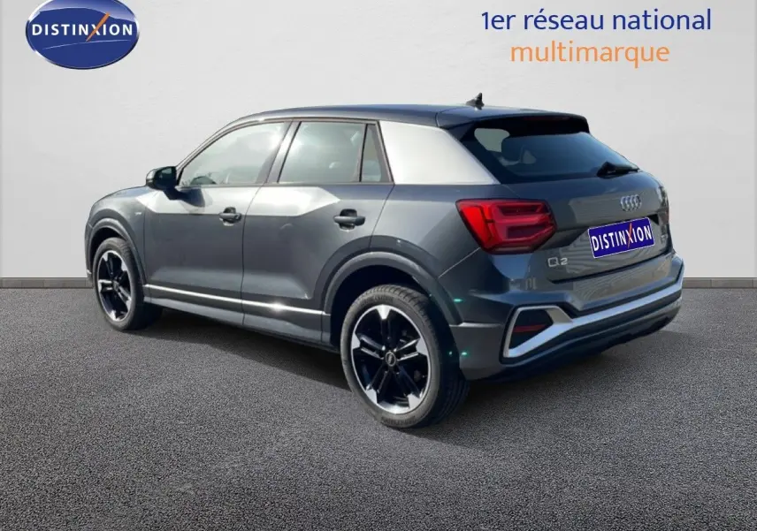 Audi Q2 30 TDI S-Line gris Manhattan, vue 3/4 arrière droit, jantes noires et toit contrasté argent.