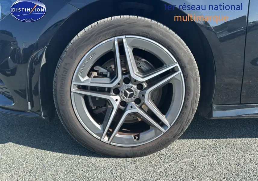 Gros plan sur la roue avant gauche noire d'une Mercedes Classe CLA 250 e AMG Line avec jante alu cinq branches.