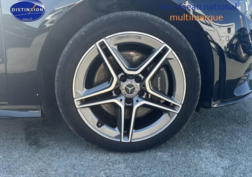 Gros plan sur la roue avant gauche noire d'une Mercedes Classe CLA 250 e AMG Line avec jante alu AMG cinq branches.