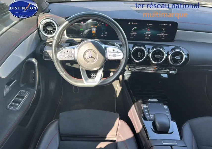Vue intérieure avant de la Mercedes Classe CLA 250 e AMG Line 2022, volant cuir noir avec surpiqûres rouges et tableau de bord digital.