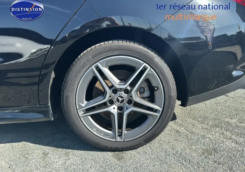 Gros plan sur la roue arrière droite d'une Mercedes Classe CLA 250 e AMG Line noire avec jante alu cinq branches.