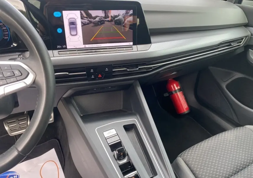 Vue intérieure côté passager avant de la Volkswagen Golf noire 2022, écran de caméra de recul et tableau de bord moderne.