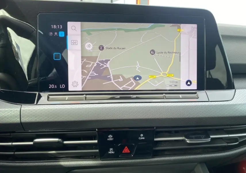 Écran tactile de navigation 10 pouces sur tableau de bord gris clair de Volkswagen Golf noire, vue frontale rapprochée.