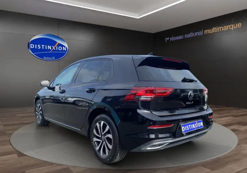 Volkswagen Golf noire vue en 3/4 arrière droit, avec vitres surteintées et feux arrière LED visibles.