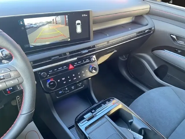 Vue intérieure côté passager du tableau de bord et console centrale du Hyundai Tucson noir avec écran tactile affichant la caméra de recul.