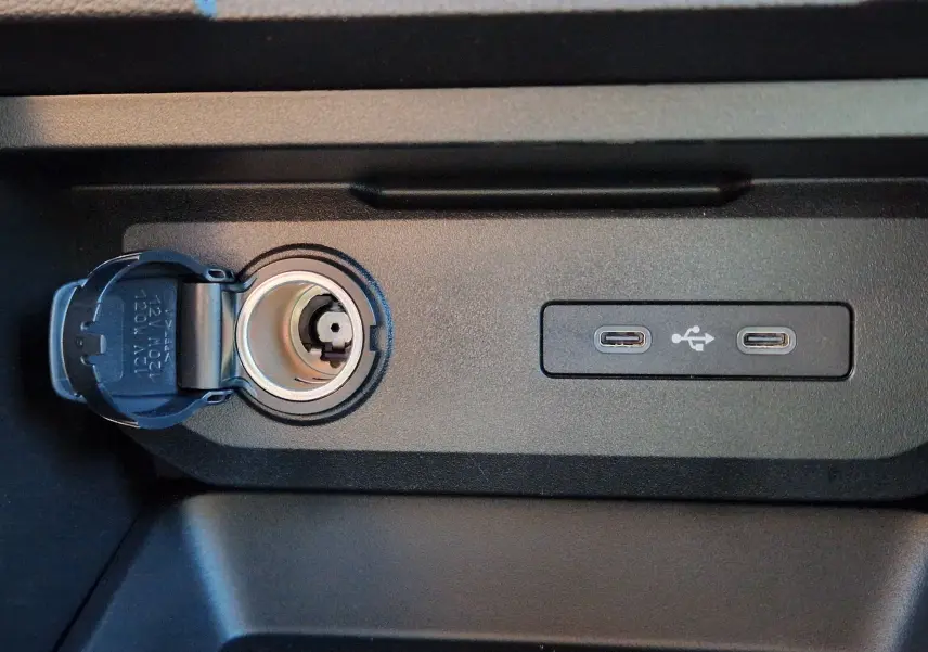 Prise allume-cigare et double port USB-C intégrés dans la console centrale du Dacia Duster blanc 2026.
