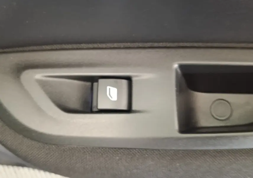 Bouton de commande de verrouillage des portes sur la portière intérieure d'une Peugeot E-2008 électrique gris clair.