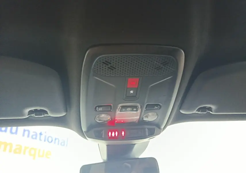 Vue intérieure du plafonnier avec commandes d’éclairage et bouton SOS du Peugeot E-2008 électrique gris clair 2023.