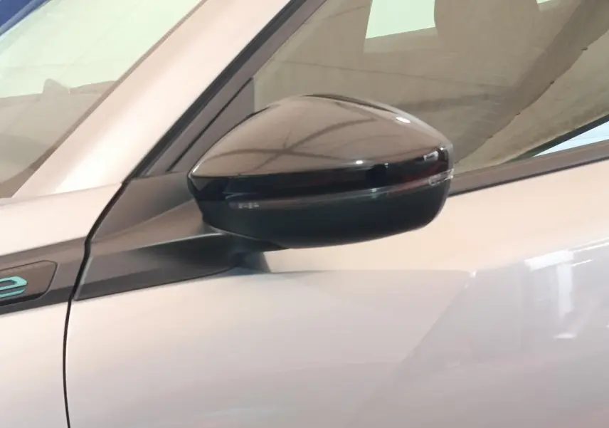 Gros plan sur le rétroviseur côté gauche noir brillant du Peugeot E-2008 électrique gris clair 2023.