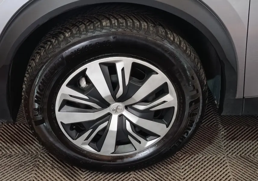 Gros plan sur la roue avant droite gris clair du Peugeot E-2008 électrique avec jante alliage et pneu Michelin.