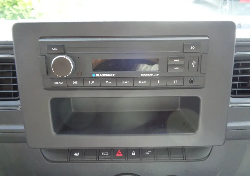 Gros plan sur la radio Blaupunkt Bologna 200 intégrée au tableau de bord noir du fourgon Opel Movano L3H2 blanc polaire.