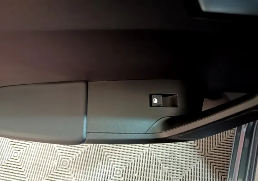 Détail de la commande de verrouillage sur la portière avant gauche d’une SEAT Leon gris clair 2023.