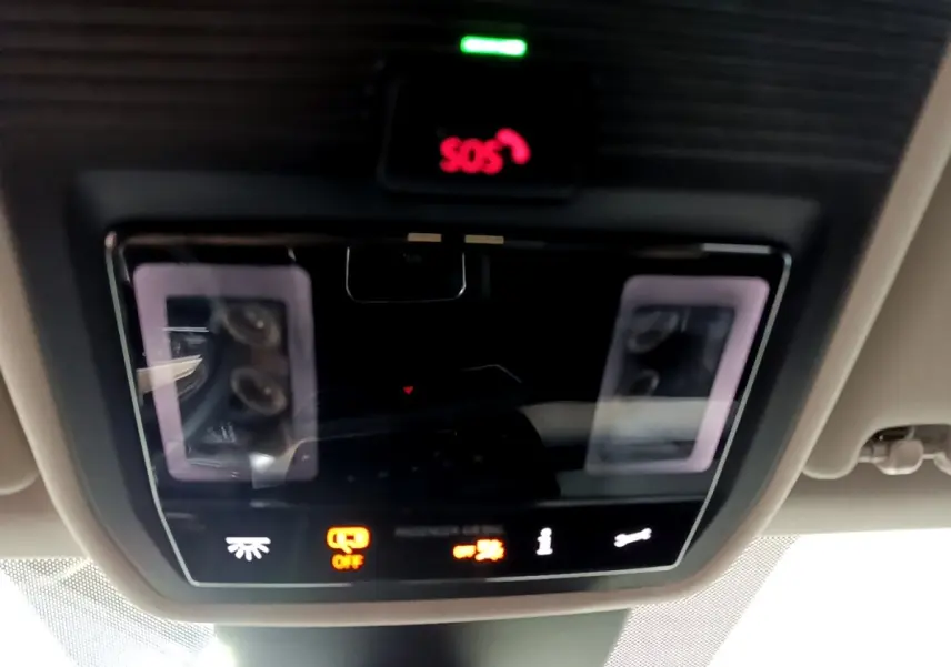 Vue en gros plan du panneau de commandes au plafond avec bouton SOS rouge et éclairage ambiant sur SEAT Leon gris clair 2023.