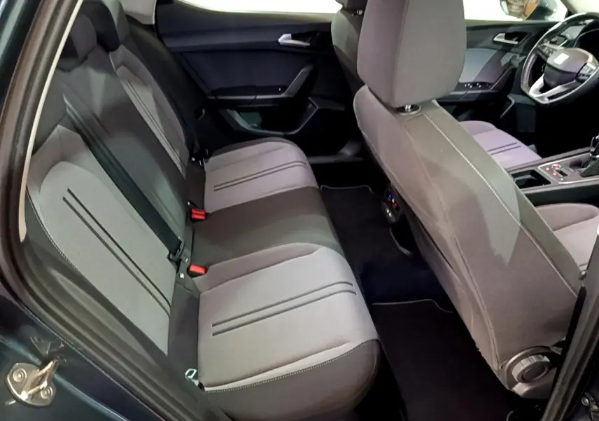 Vue intérieure côté gauche montrant la banquette arrière grise et les sièges avant du SEAT Leon 2023.