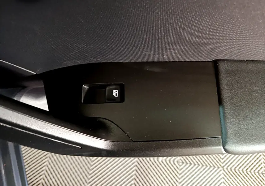 Gros plan sur le bouton de verrouillage centralisé sur la portière côté conducteur d'une SEAT Leon gris clair 2023.