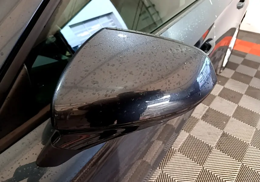 Rétroviseur droit gris clair de la SEAT LEON 2023, vue rapprochée avec gouttes d'eau sur la carrosserie.