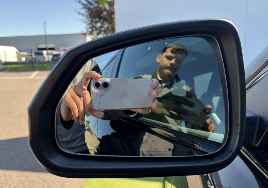 Rétroviseur extérieur droit noir d'une BMW X1 2025 noir saphir avec surface miroir et reflet partiel.