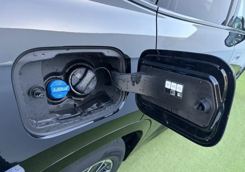 Bouchon de réservoir diesel et AdBlue ouvert sur le côté gauche d'une BMW X1 noir saphir, vue rapprochée.
