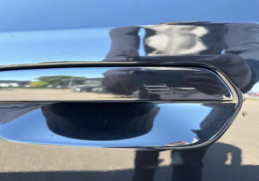 Poignée de porte noire Saphir en gros plan sur BMW X1 2025, reflet brillant et contours chromés visibles.