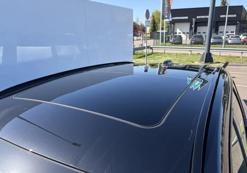 Toit ouvrant panoramique en verre du BMW X1 noir Saphir vu en plongée depuis l'arrière droit.