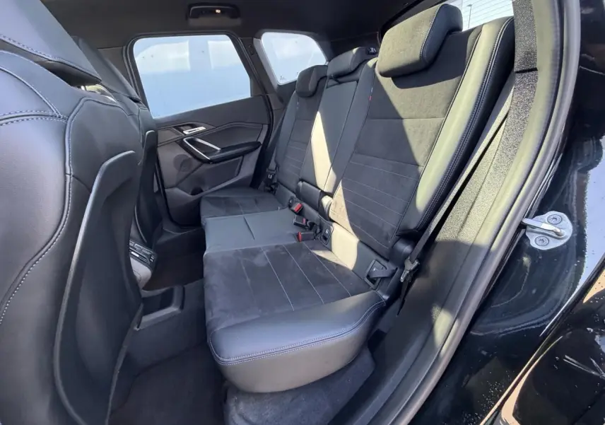 Vue intérieure côté droit sur la banquette arrière en Alcantara noir avec surpiqûres bleues du BMW X1 noir saphir.