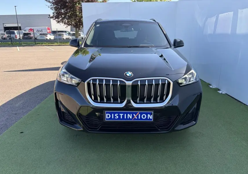 BMW X1 noir saphir vue de face, mettant en valeur la calandre imposante et les phares LED avancés.