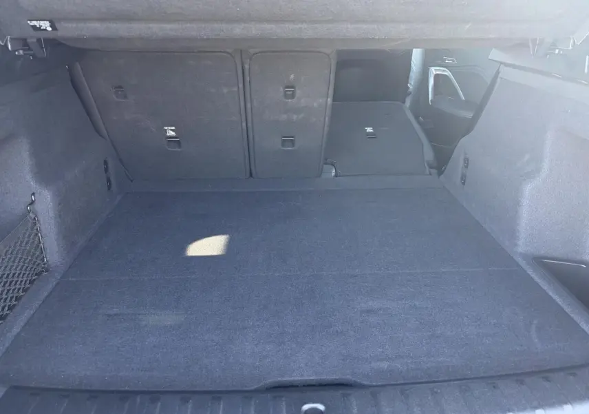 Coffre spacieux de BMW X1 noir Saphir, vue intérieure arrière avec banquette arrière partiellement rabattue.