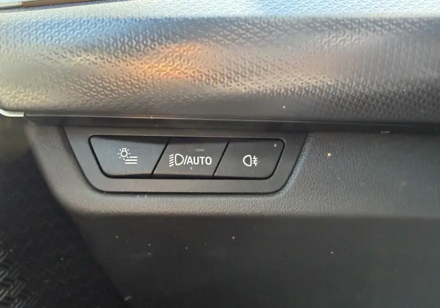 Gros plan sur les commandes d'éclairage intérieures noires du BMW X1 noir Saphir, version 2025.