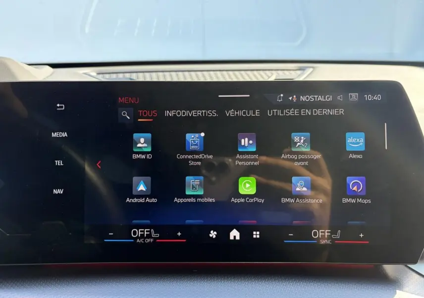 Écran tactile incurvé du tableau de bord du BMW X1 noir, affichant les applications connectées et options multimédia.