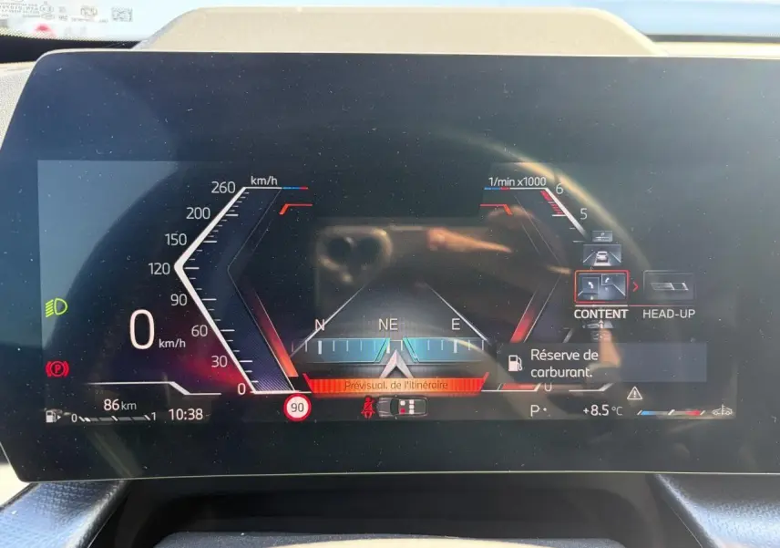 Affichage numérique du combiné d'instruments du BMW X1 noir, avec indication vitesse, navigation et alertes visibles.